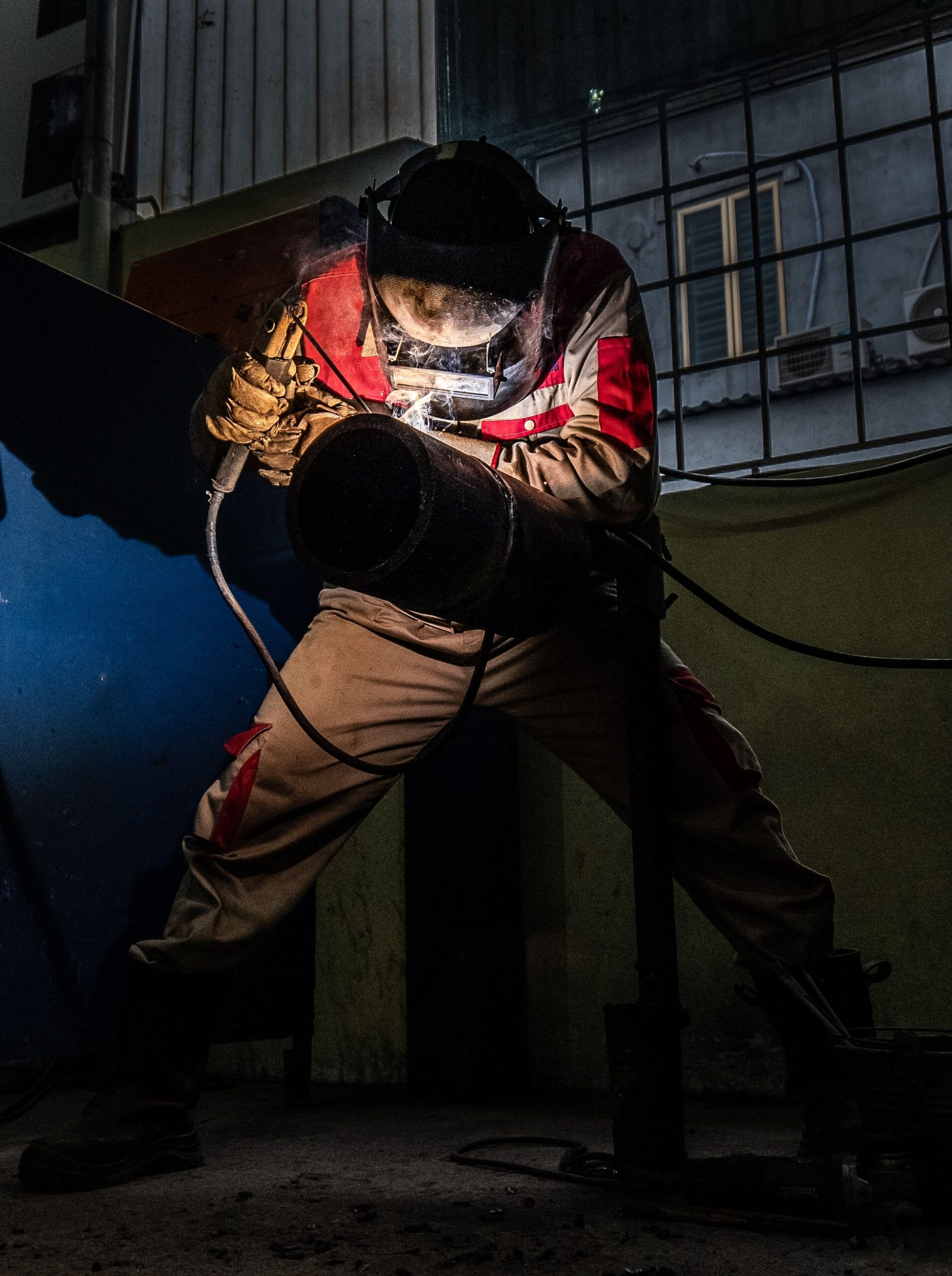 Welder welding a steel pipe at night