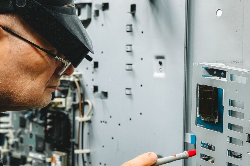 Engineer in safety equipment inspecting industrial equipment with measuring tools